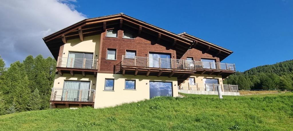 La casa in estate circondata dai prati verdi e dalle montagne