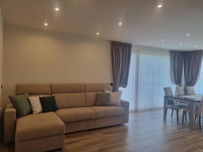 Divano beige con cuscini verdi nel soggiorno luminoso